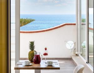 een kamer met een tafel en uitzicht op de oceaan bij Pantanello Rooms Avola in Avola