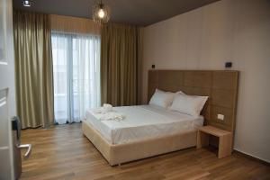 een slaapkamer met een groot bed en een groot raam bij Hotel Lubjana in Durrës