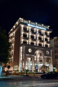 een hotelgebouw met 's nachts verlichting bij Hotel Lubjana in Durrës