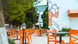 an empty patio with orange chairs and tables at Club Beyy Resort Hotel - Ultra All Inclusive in Izmir