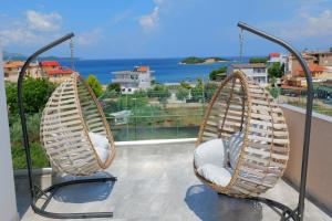 2 stoelen op een balkon met uitzicht op de oceaan bij Hotel Alexander in Ksamil