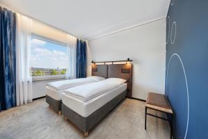 Кровать или кровати в номере H2 Hotel Düsseldorf City