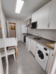 een keuken met een wasmachine en een tafel bij Apartamento Santander Maliaño in Maliaño