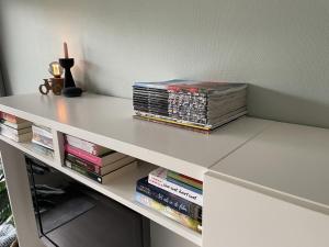 une table blanche avec des livres au-dessus dans l'établissement CallantsDuinzicht, Beachappartement 24, à Callantsoog