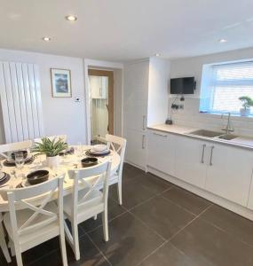 une cuisine avec une table et des chaises dans l'établissement Modern 4-bed Cottage Llanwrst Town Centre & Parking - Snowdonia! near Betws-y-Coed, à Llanrwst