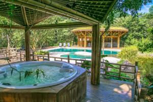 Banana Bamboo Ecolodge في أوباتوبا: حوض جاكوزي على سطح بجوار حمام سباحة