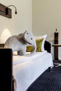 um elefante de peluche sentado em cima de uma cama em The Lodge Billund em Billund