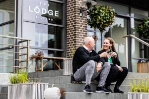 um homem e uma mulher sentados nos degraus de um edifício em The Lodge Billund em Billund