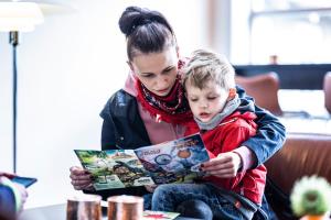 uma mulher e uma criança a ler um livro em The Lodge Billund em Billund