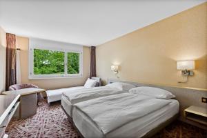 A bed or beds in a room at becozy Au Parc Retro Edition Self-Check-In Rooms & Studios Fribourg