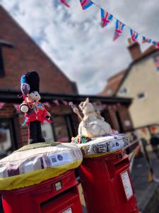 deux personnages de jouets assis au-dessus d’une cabine téléphonique rouge dans l'établissement Frankland - Emsworth Harbour 3 Bedroom House, à Emsworth