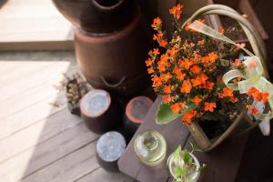 uma mesa com um vaso de flores e alguns potes em Red Clay pension em Gangneung