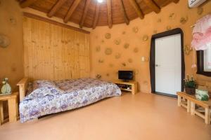 um quarto com uma cama e uma televisão num quarto em Red Clay pension em Gangneung