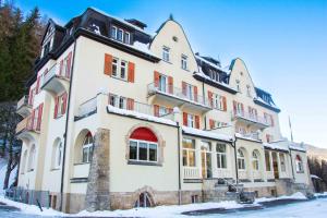 duży budynek z śniegiem na ziemi w obiekcie Gruppenhaus Lindenhof Churwalden w mieście Churwalden