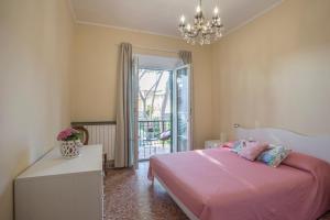 um quarto com uma cama rosa e um lustre em Piombino Apartments - Villa Pari em Piombino