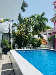 a swimming pool in front of a building with palm trees at The Quetzal in Cancún