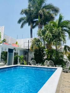 a swimming pool in front of a house with palm trees at The Quetzal in Cancún