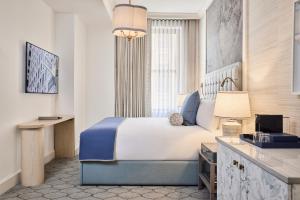 a hotel room with a bed and a desk at The Wall Street Hotel New York City in New York