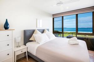 Tempat tidur dalam kamar di Azure Absolute Beachfront I Pet Friendly