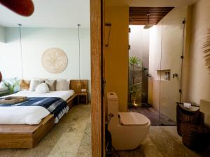 1 dormitorio con 1 cama y baño con ducha en Kai Villas Lombok, en Kuta Lombok