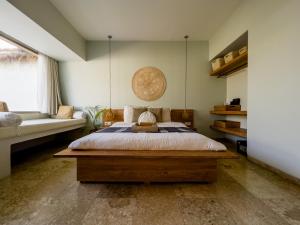 1 dormitorio con 1 cama grande y 1 sofá en Kai Villas Lombok, en Kuta Lombok