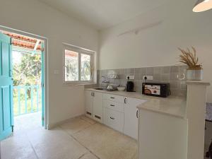 a kitchen with white cabinets and a counter top at Beseco Bed and Breakfast in Benaulim