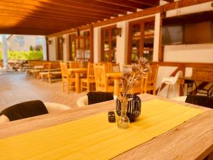 uma mesa de madeira com um vaso com flores em Sommer Panzió em Balatonföldvár