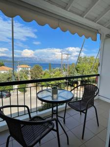 una mesa y sillas en un balcón con vistas al océano en Sunshine Apartments and Rooms, en Nikiana