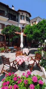 um pátio com uma mesa, cadeiras e flores em Villa Sunray em Agios Ioannis Pelio