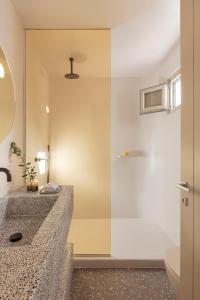 a bathroom with a sink and a shower at Ethos Vegan Suites in Fira