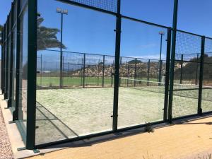 un campo da tennis è visibile attraverso una finestra di São Torpes by Campigir a Sines