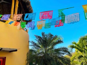 a string of flags hanging from a building with palm trees at Casa Boho 1 in Sayulita