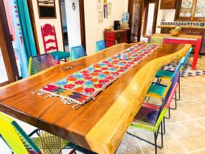 a wooden table with colorful chairs around it at Casa Boho 1 in Sayulita