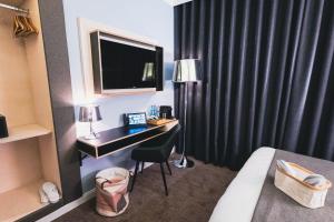 una camera d'albergo con scrivania, TV e letto di MountainPark | Event- und Tagungshotel a Kassel