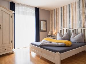 um quarto com uma cama com um cobertor amarelo em Margret Haus em Balatonfüred