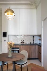 a kitchen with a wooden table and a vase of flowers at Joro Living in Paris