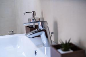 La salle de bains est pourvue d'un lavabo avec un robinet en chrome. dans l'établissement Sziklai Apartman, à Veszprém