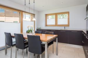 a kitchen with a wooden table and black chairs at Ferienhaus Casa Luna in Zermatt