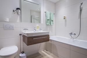 a bathroom with a sink and a tub and a toilet at Ferienhaus Casa Luna in Zermatt