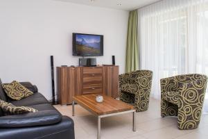 a living room with a couch and chairs and a tv at Ferienhaus Casa Luna in Zermatt