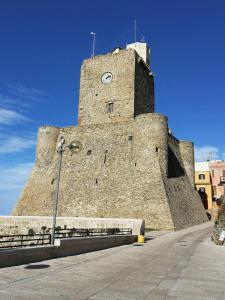 un grand bâtiment en pierre avec une tour d'horloge dans l'établissement Azzurro come il Mare, à Termoli