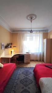 ein Schlafzimmer mit einem Schreibtisch und einem großen Fenster mit einer Fensterbank in der Unterkunft Cozy room in Kaunas in Kaunas