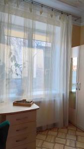 Zimmer mit einer Kommode und einem Fenster mit Vorhängen in der Unterkunft Cozy room in Kaunas in Kaunas