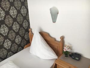 um quarto com uma cama com uma almofada branca e um candeeiro em Hotel und Restaurant -Gasthaus Zur Pfalz em Hockenheim