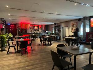 un restaurant avec des tables, des chaises et un éclairage rouge dans l'établissement Mutrah Hotel, à Mascate