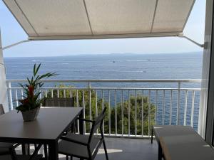 a balcony with a table and chairs and a view of the ocean at OverTheSea - PUEBLECITO Apartment in Roses