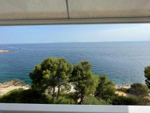 a view of the ocean from a window at OverTheSea - PUEBLECITO Apartment in Roses