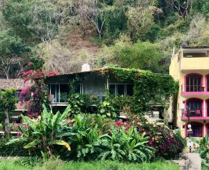 a house with flowers and plants in front of it at Casa Cereza Apartments in Puerto Vallarta