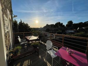 einen Balkon mit Tisch und Stühlen und Sonnenuntergang in der Unterkunft Les 3 pigeons in Bressuire