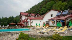 ein Resort mit einem Pool und Liegestühlen in der Unterkunft Pensiunea Alpin in Păltiniş